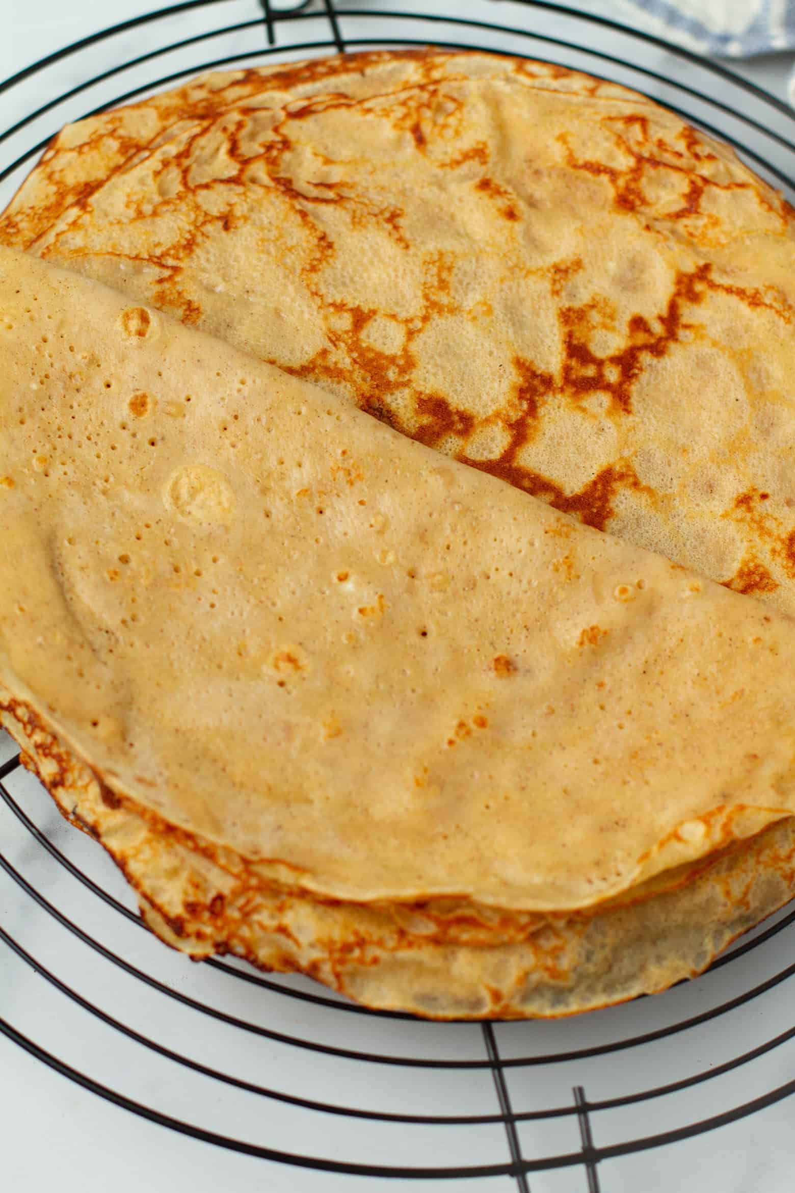 Apple crepes on a cooling rack showing the inside of a crepe.