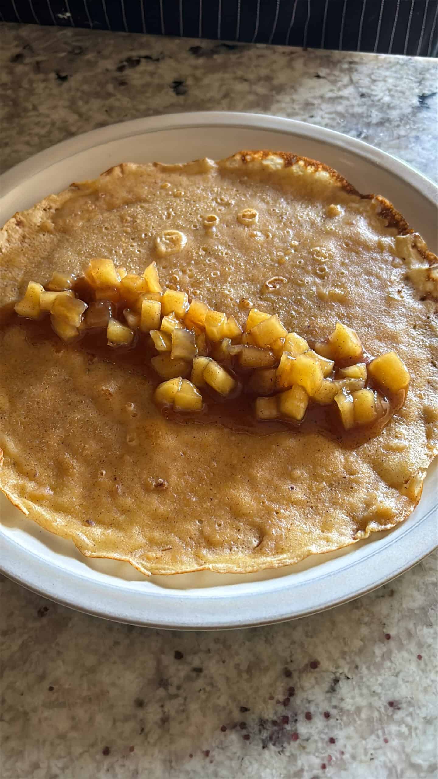 apple filling placed in side of a crepe.