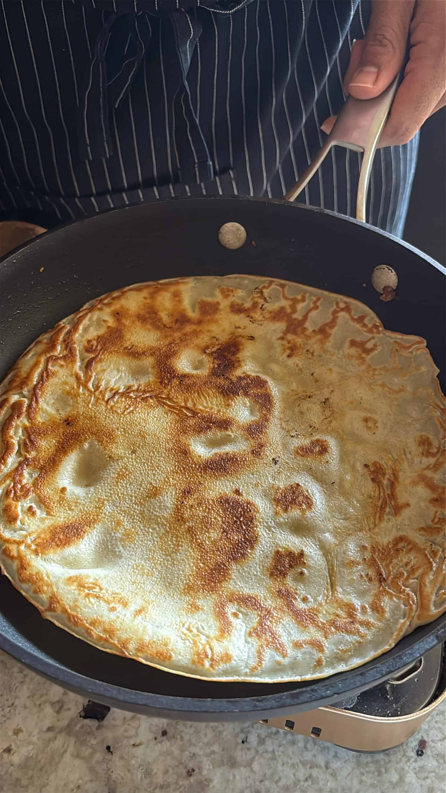 banana crepes cooking on the second side.