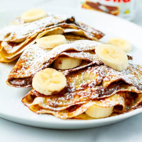 Banana nutella crepes on a plate.