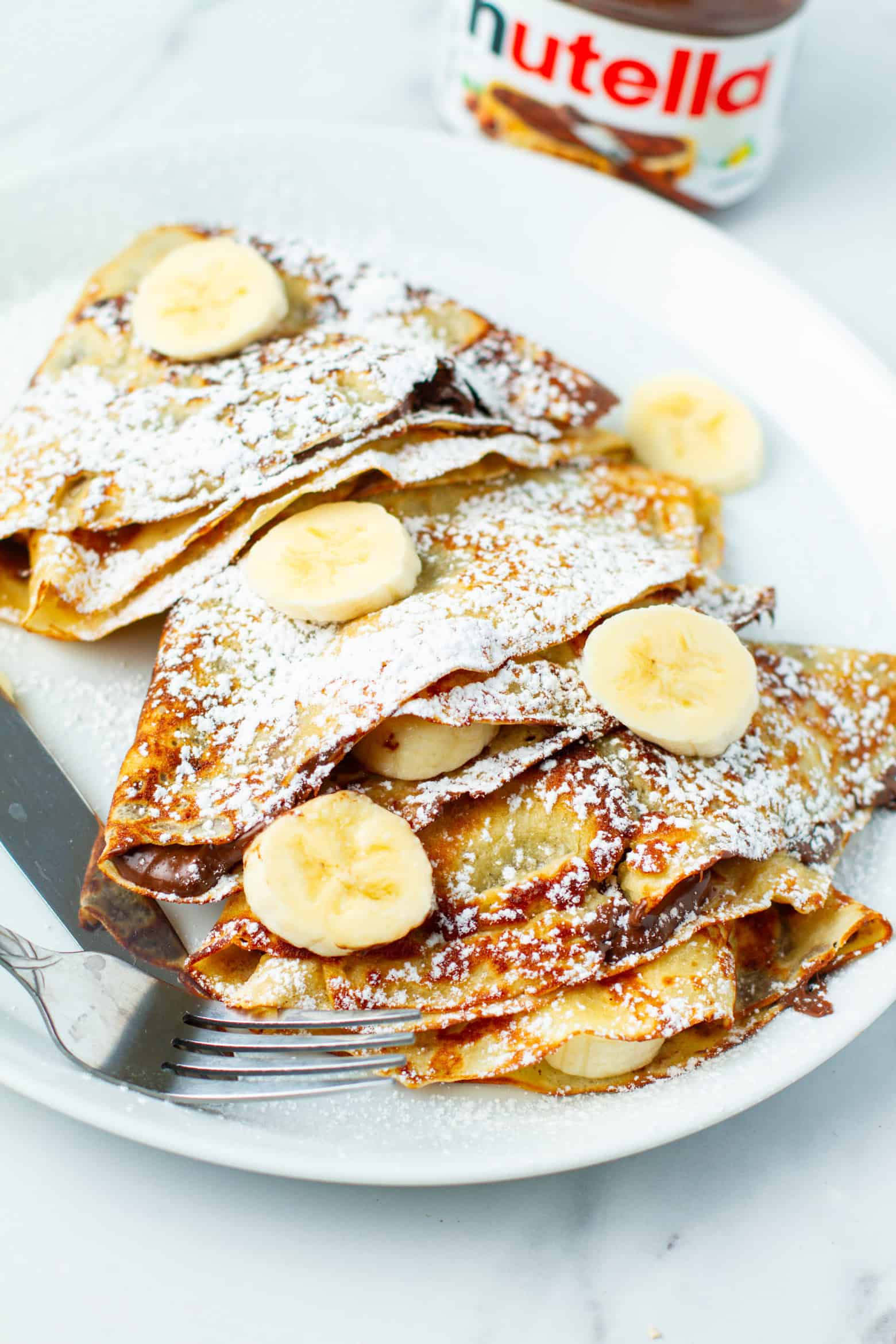Banana nutella crepes on a plate.