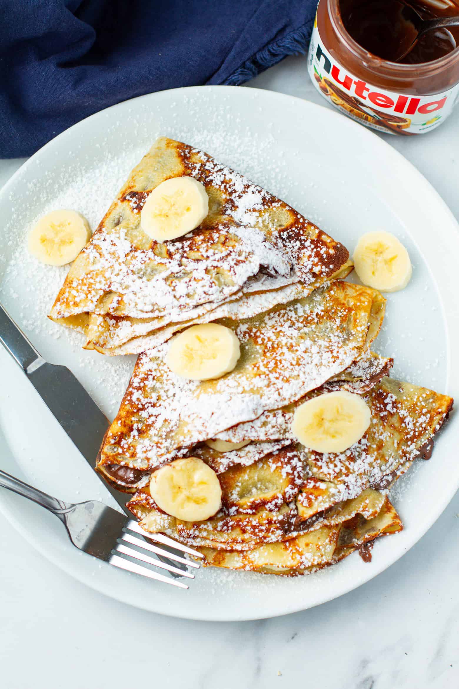 Banana nutella crepes on a plate.