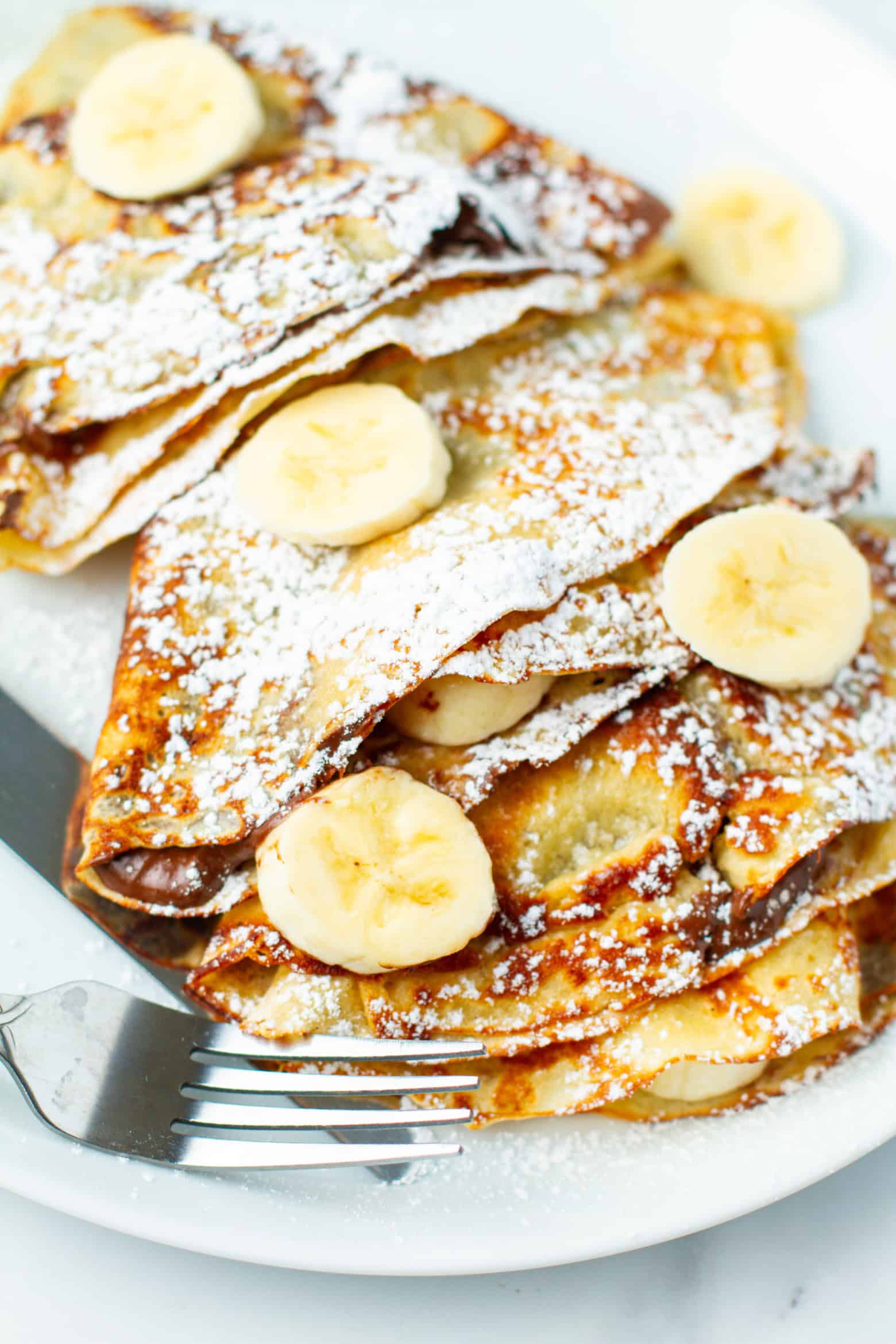 Banana nutella crepes on a plate.