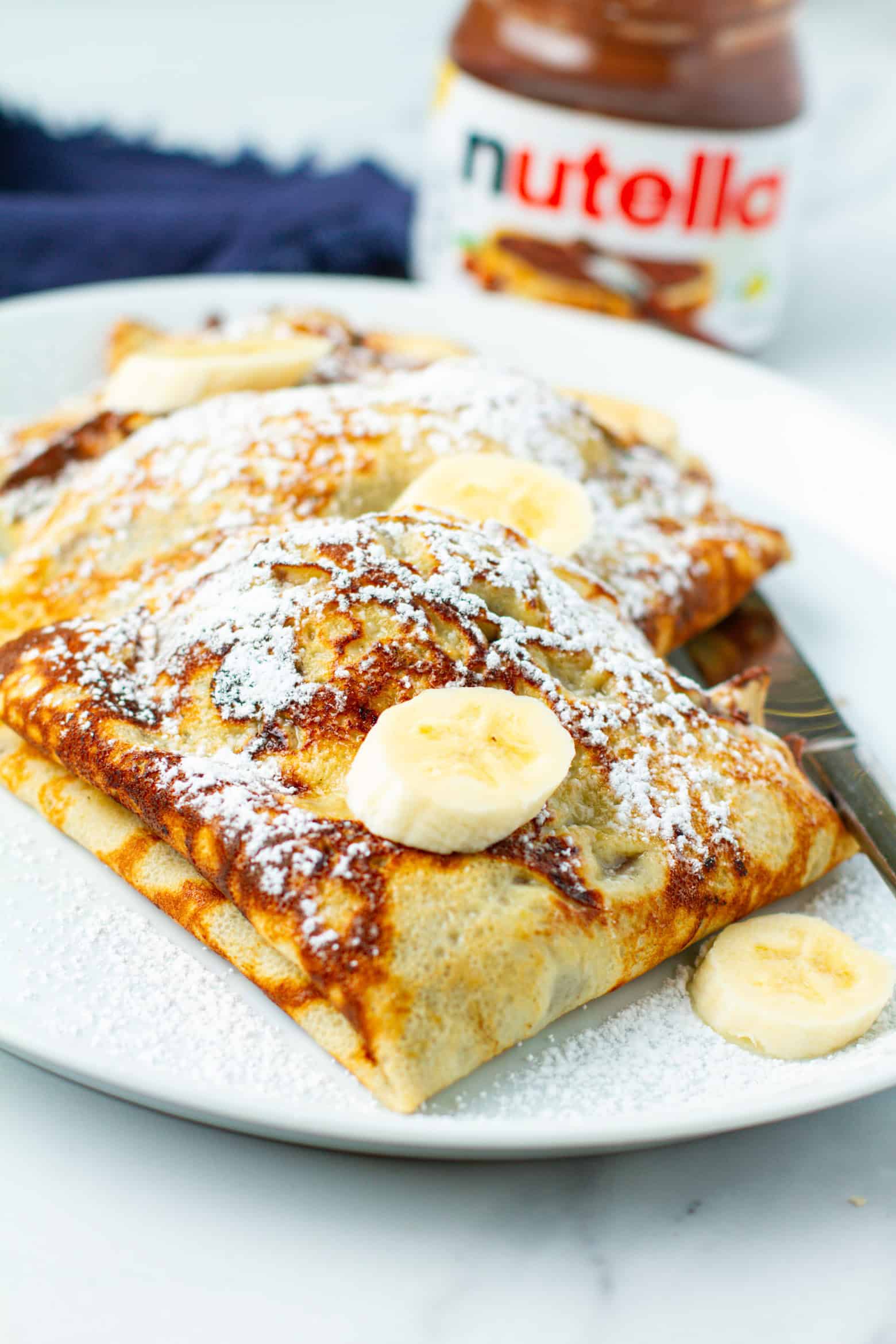 Banana nutella crepes on a plate.