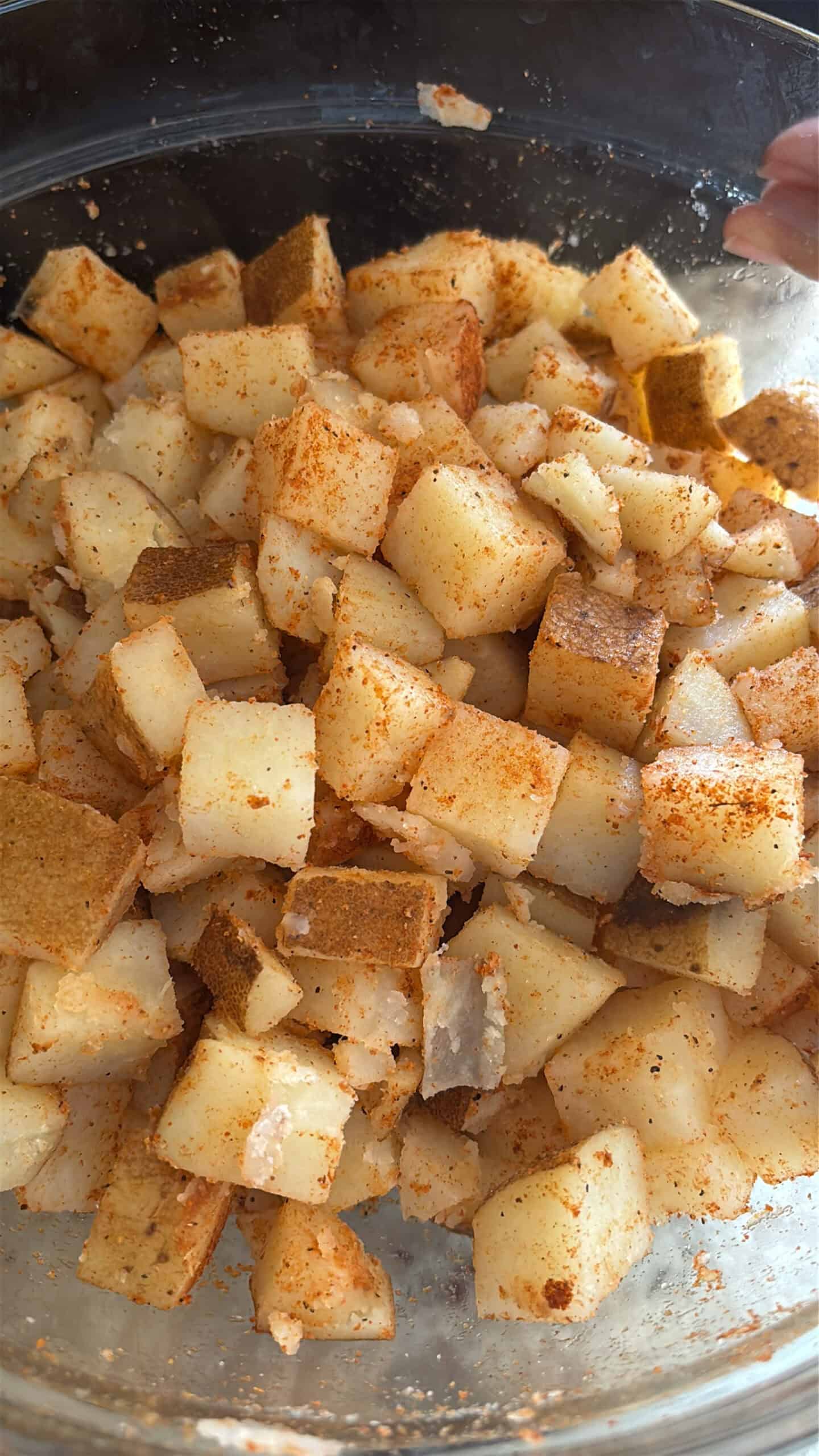 Potatoes tossed in seasoning before being fried.