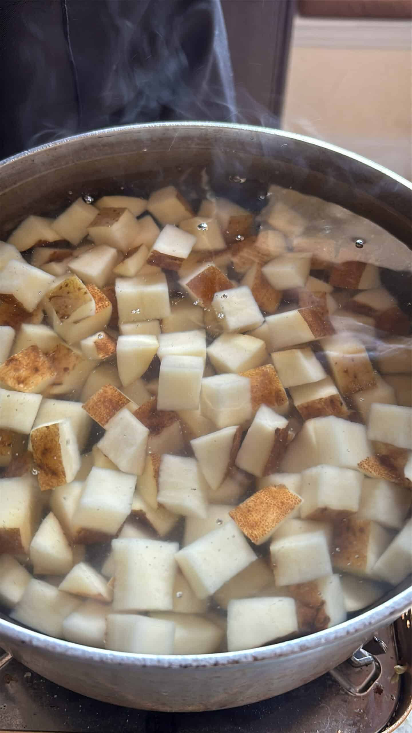 Potatoes starting to boil in a pot of water.