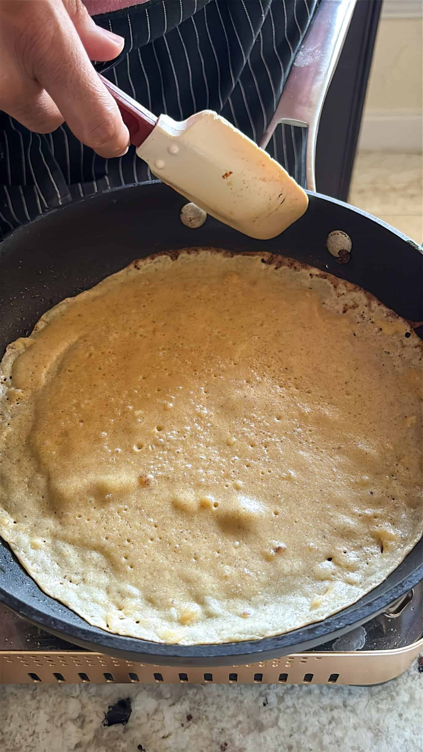 crepes cooking in a skillet.