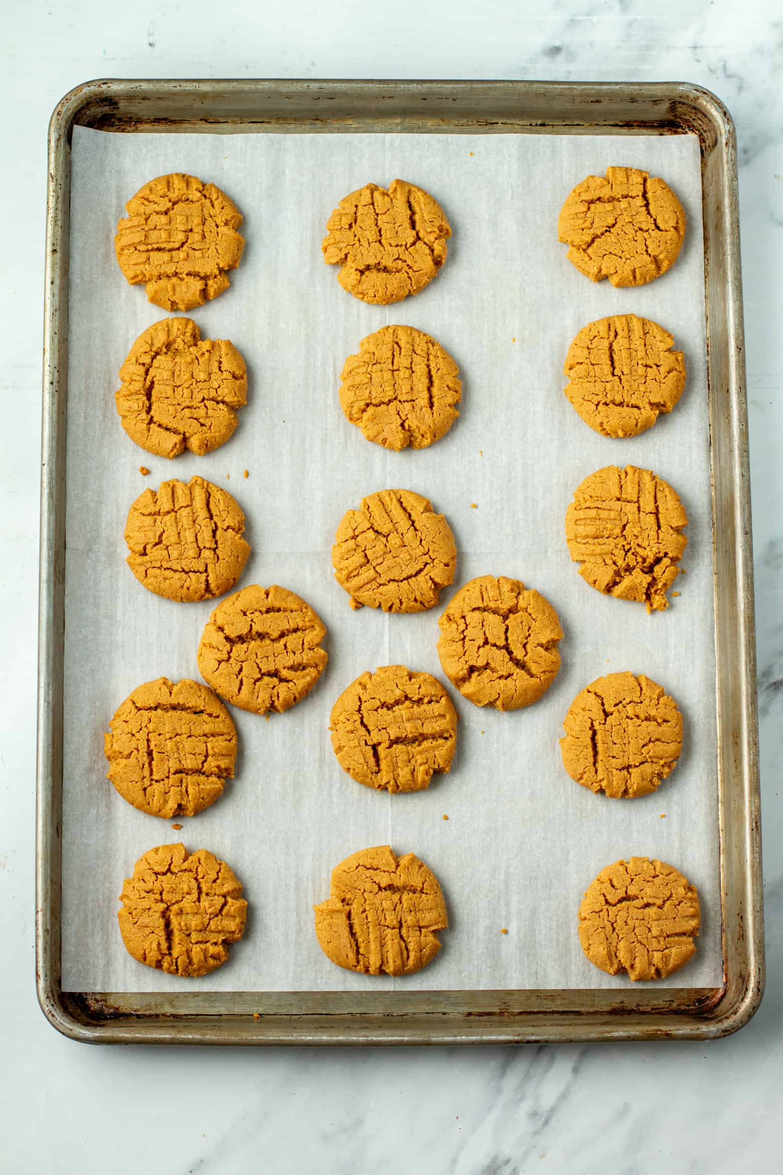 Baked peanut butter cookies on a baking sheet.