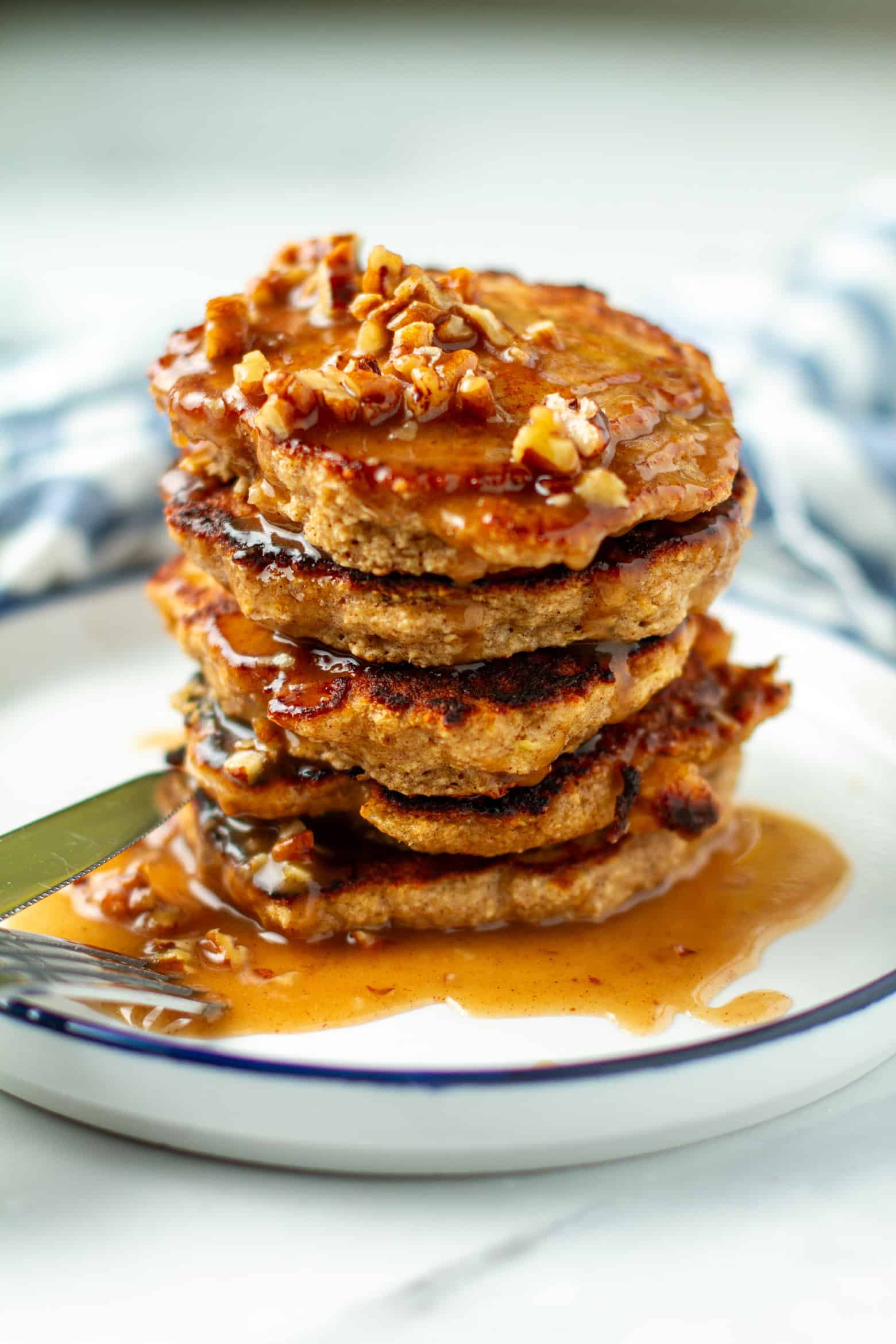 Stack of apple oat pancakes with maple butter pecan syrup.