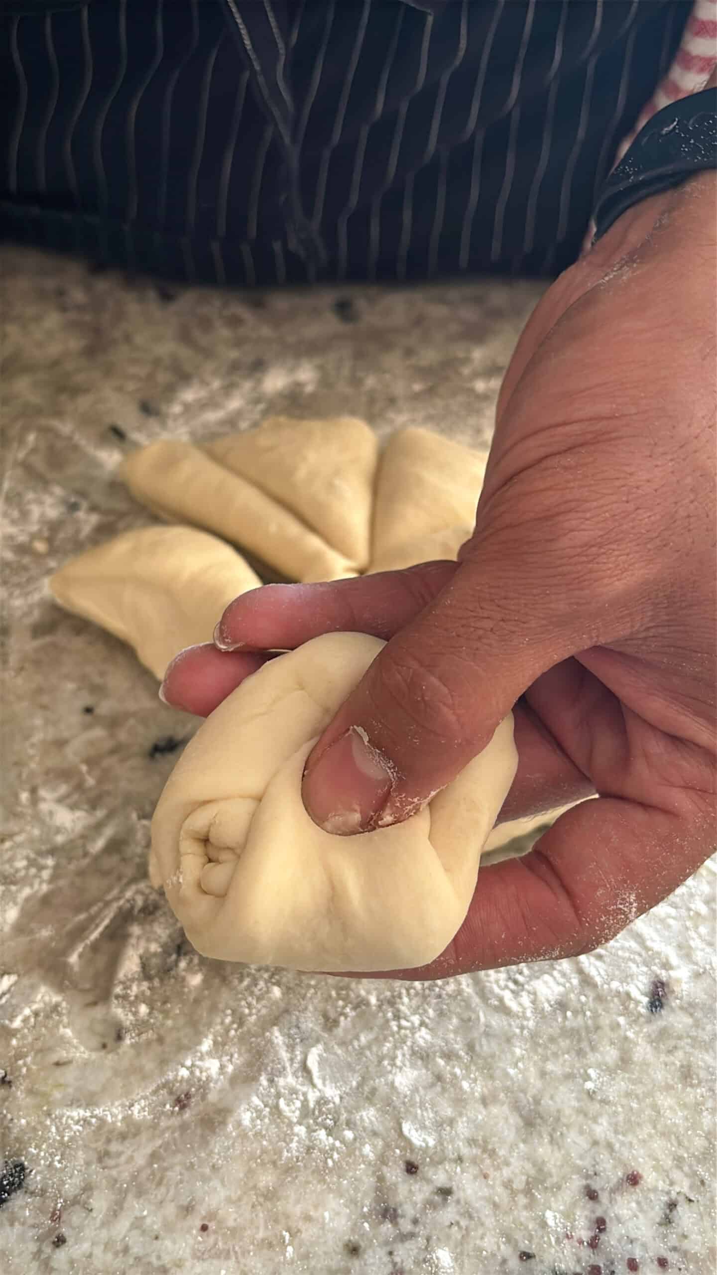 Dough ball being shaped in hands.