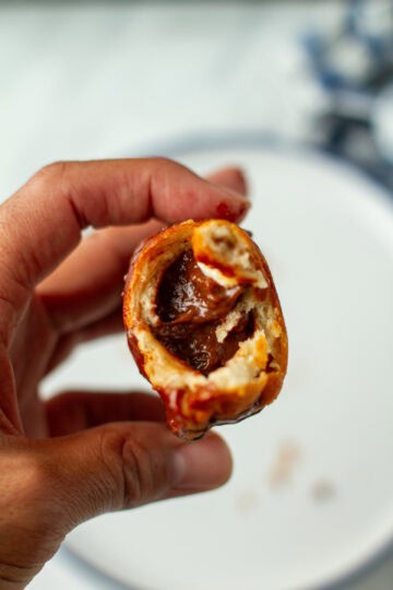 Bitten chocolate hand pie in a hand.