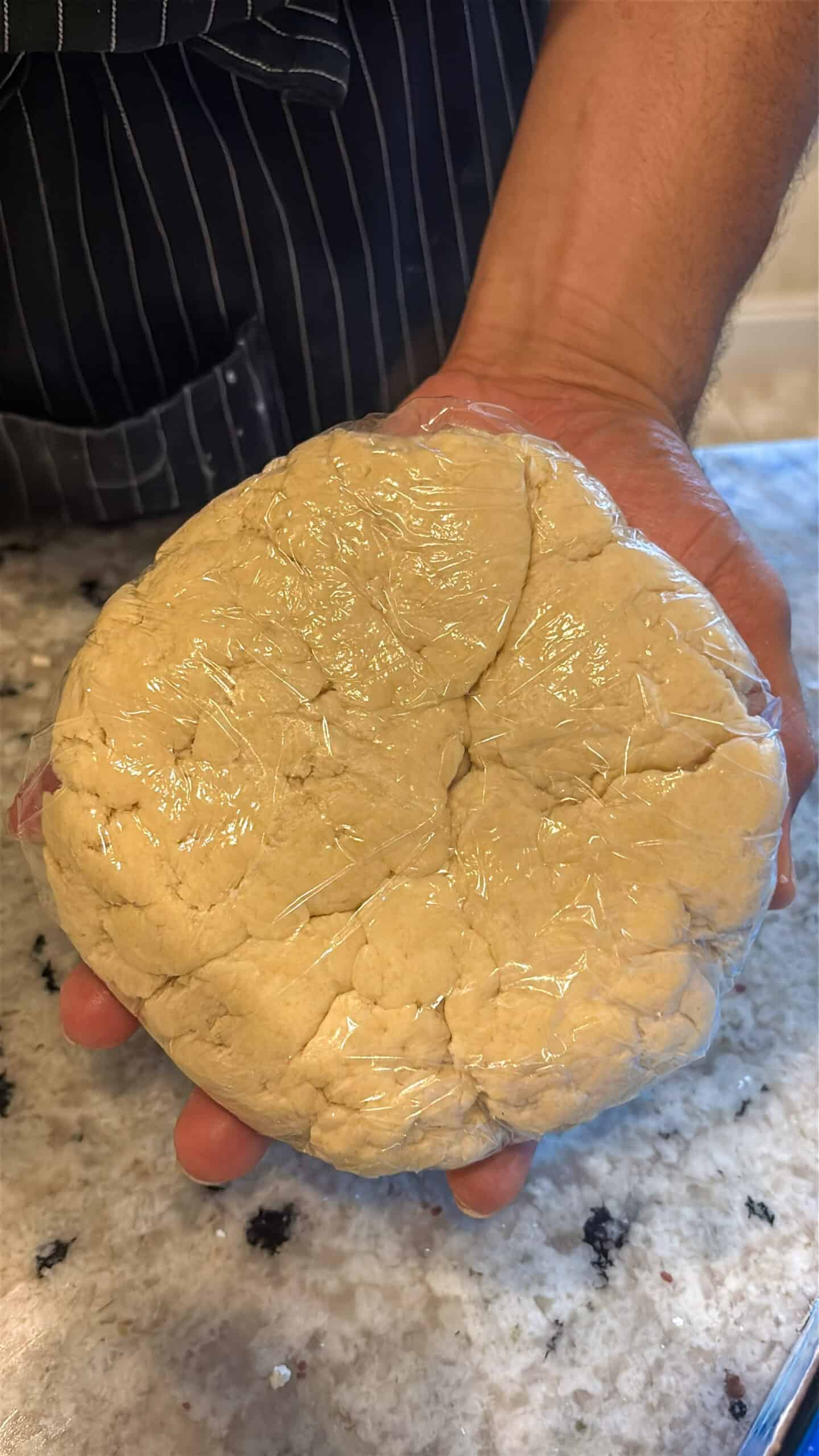 Pie dough wrapped in plastic wrap to chill.