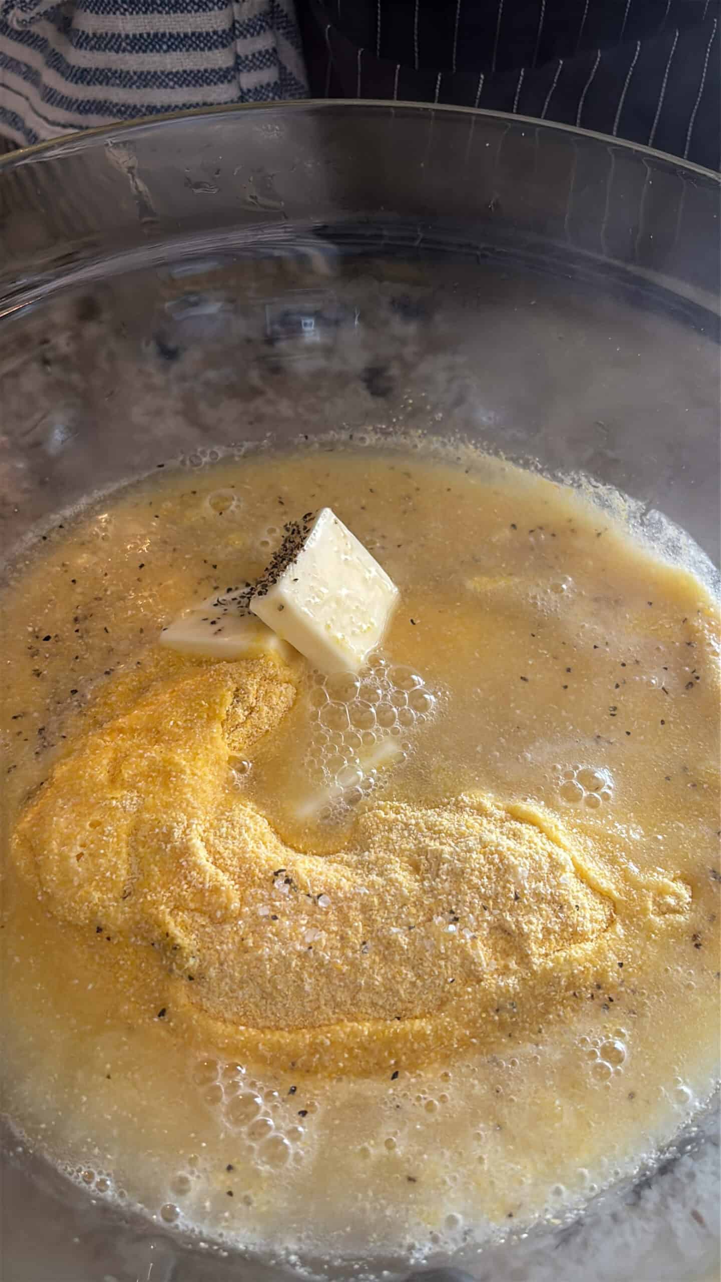 Cornmeal, hot water, butter, salt, pepper and sugar in a bowl.