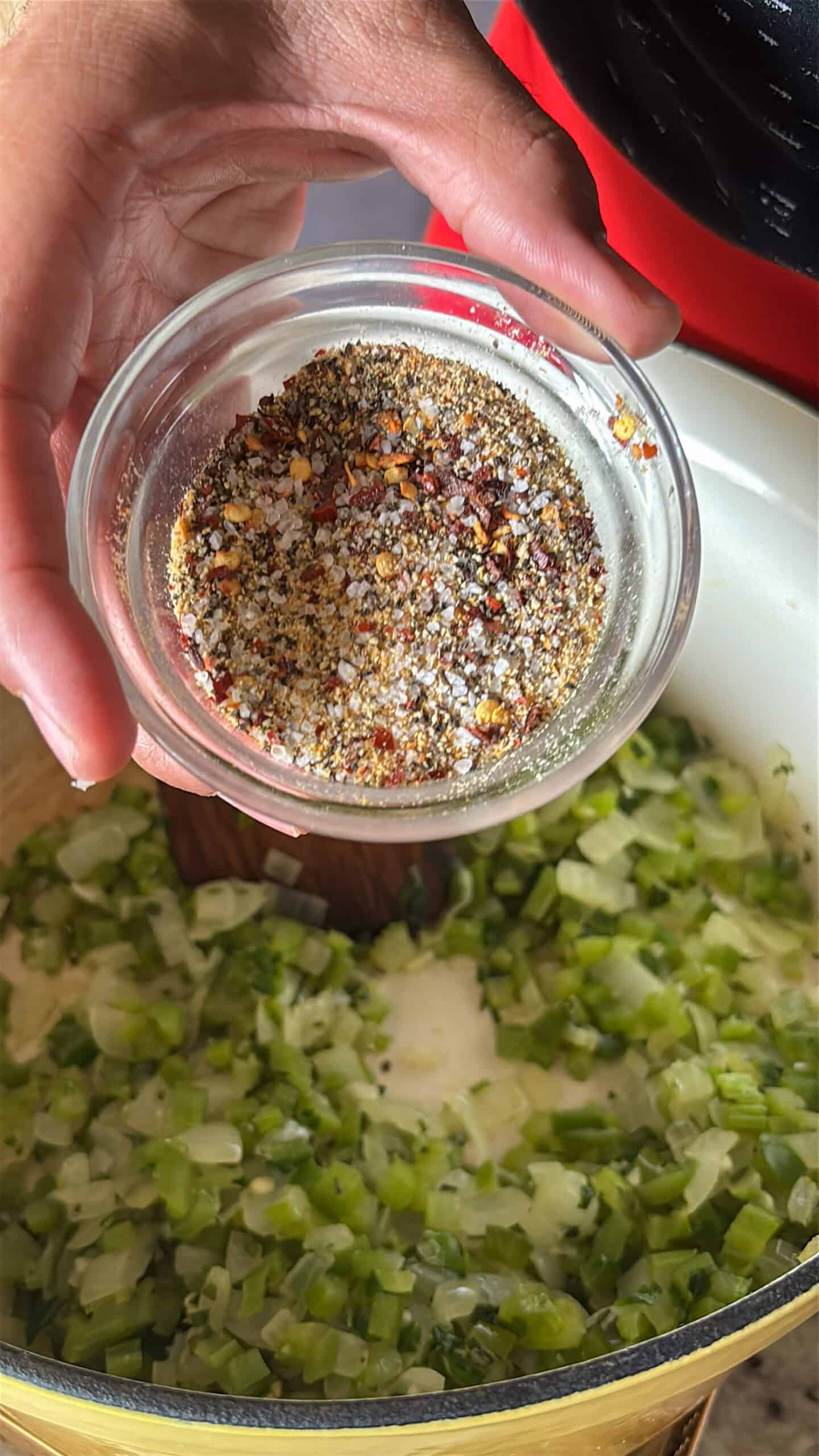 Seasoning mix being added to vegetables.
