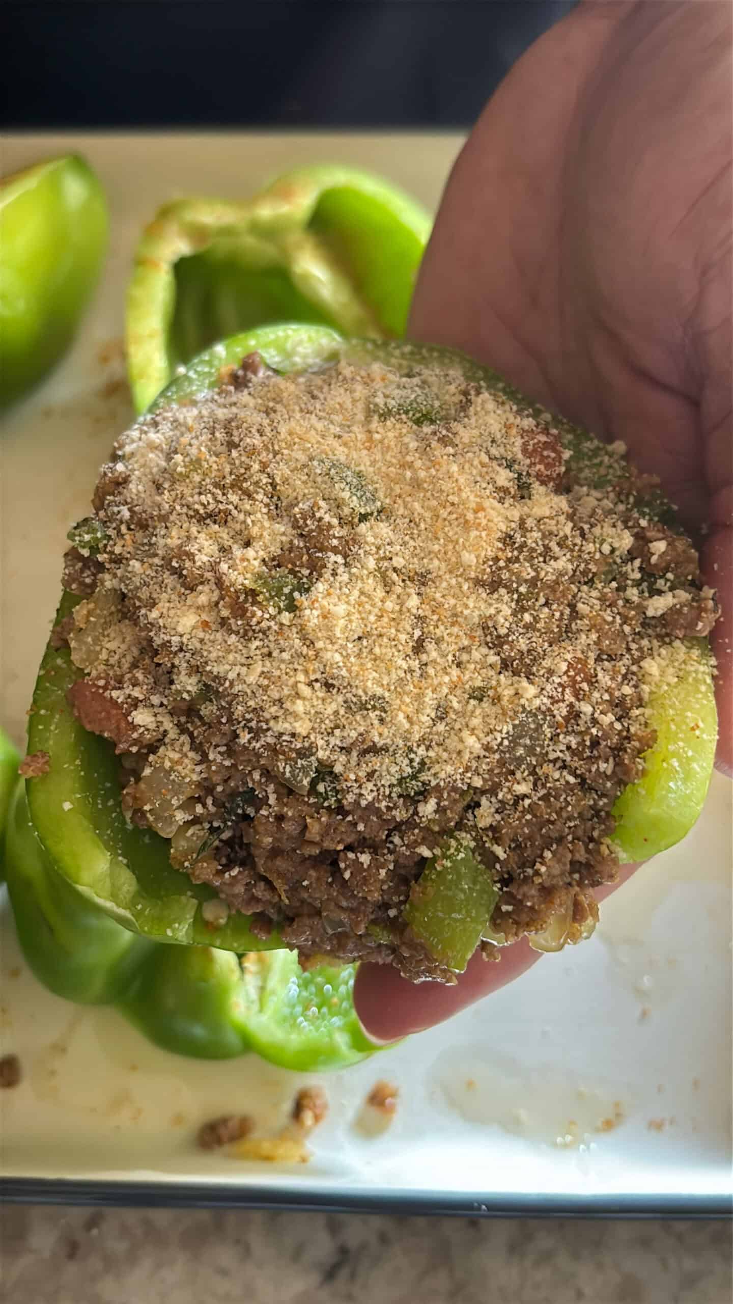 Stuffed bell pepper being held in hand.