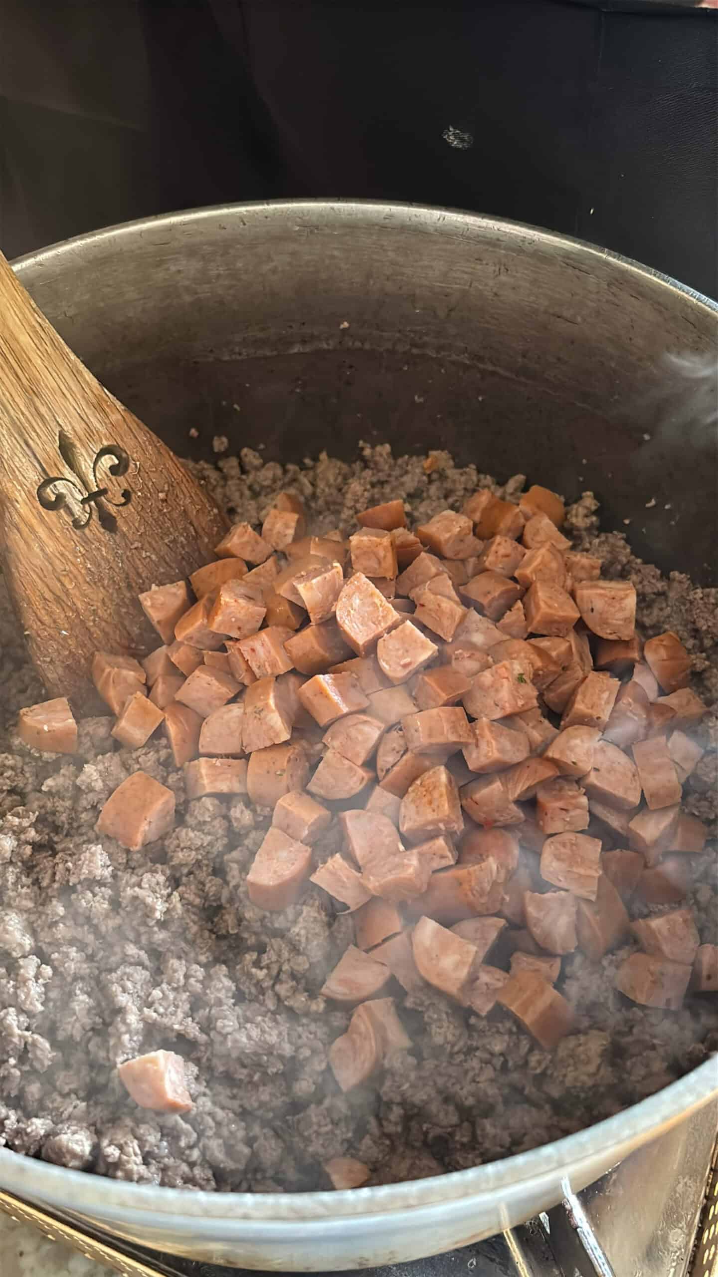 Smoked sausage cooking with ground beef.
