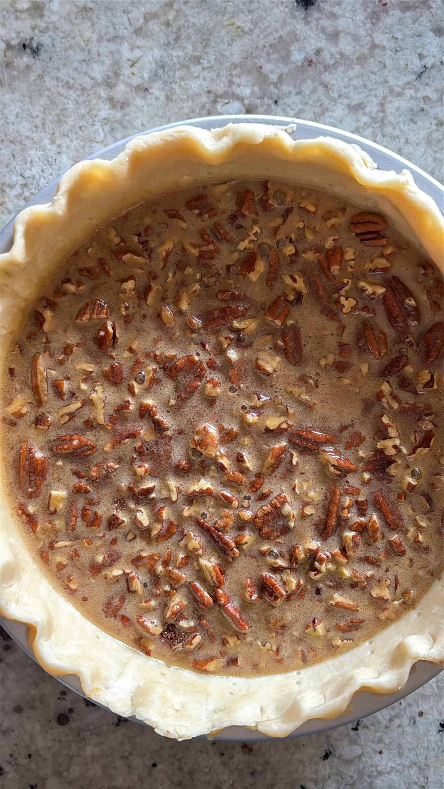 Pecan pie filling added to uncooked pie crust.