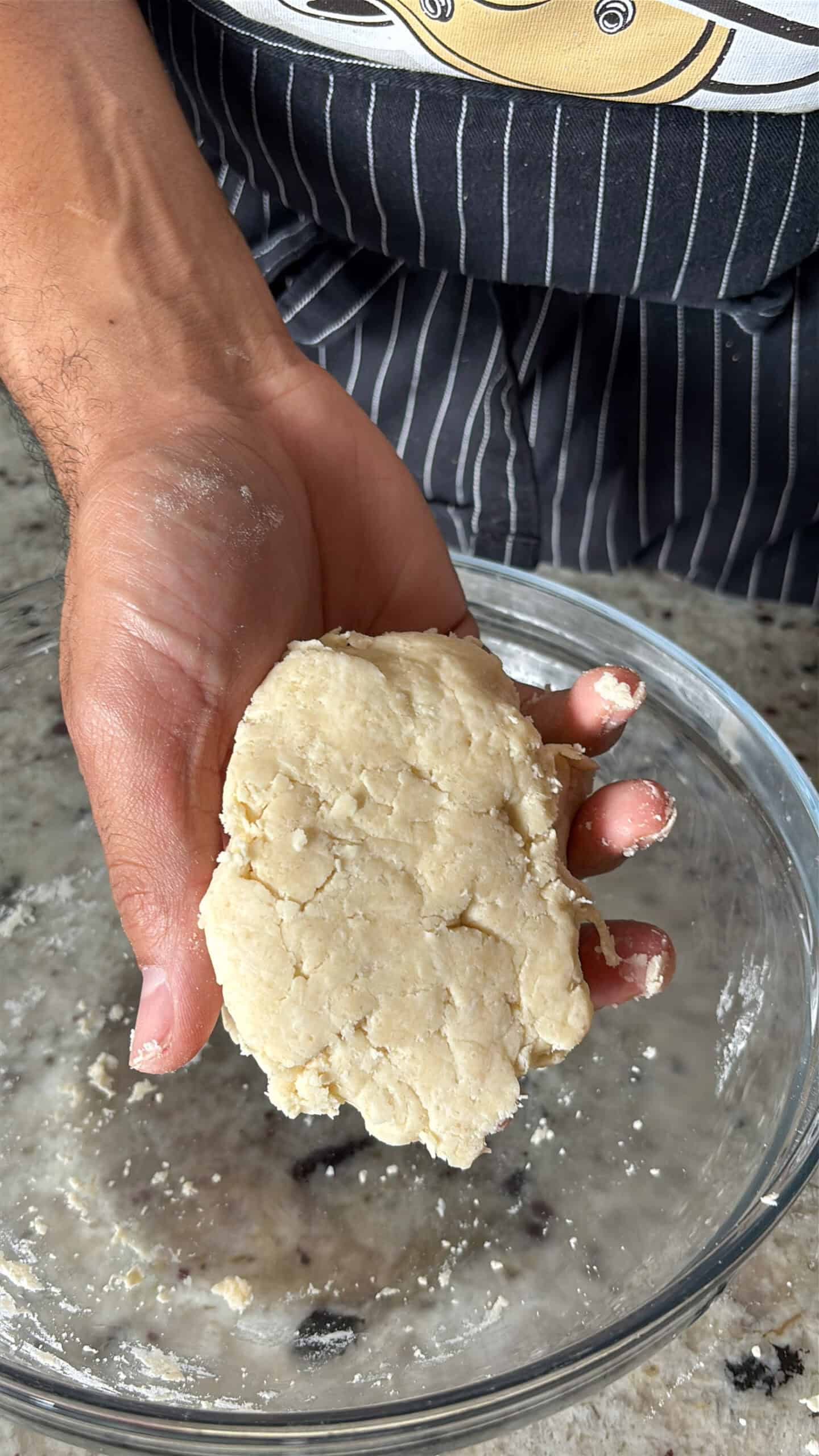 Pie dough in someones hand.