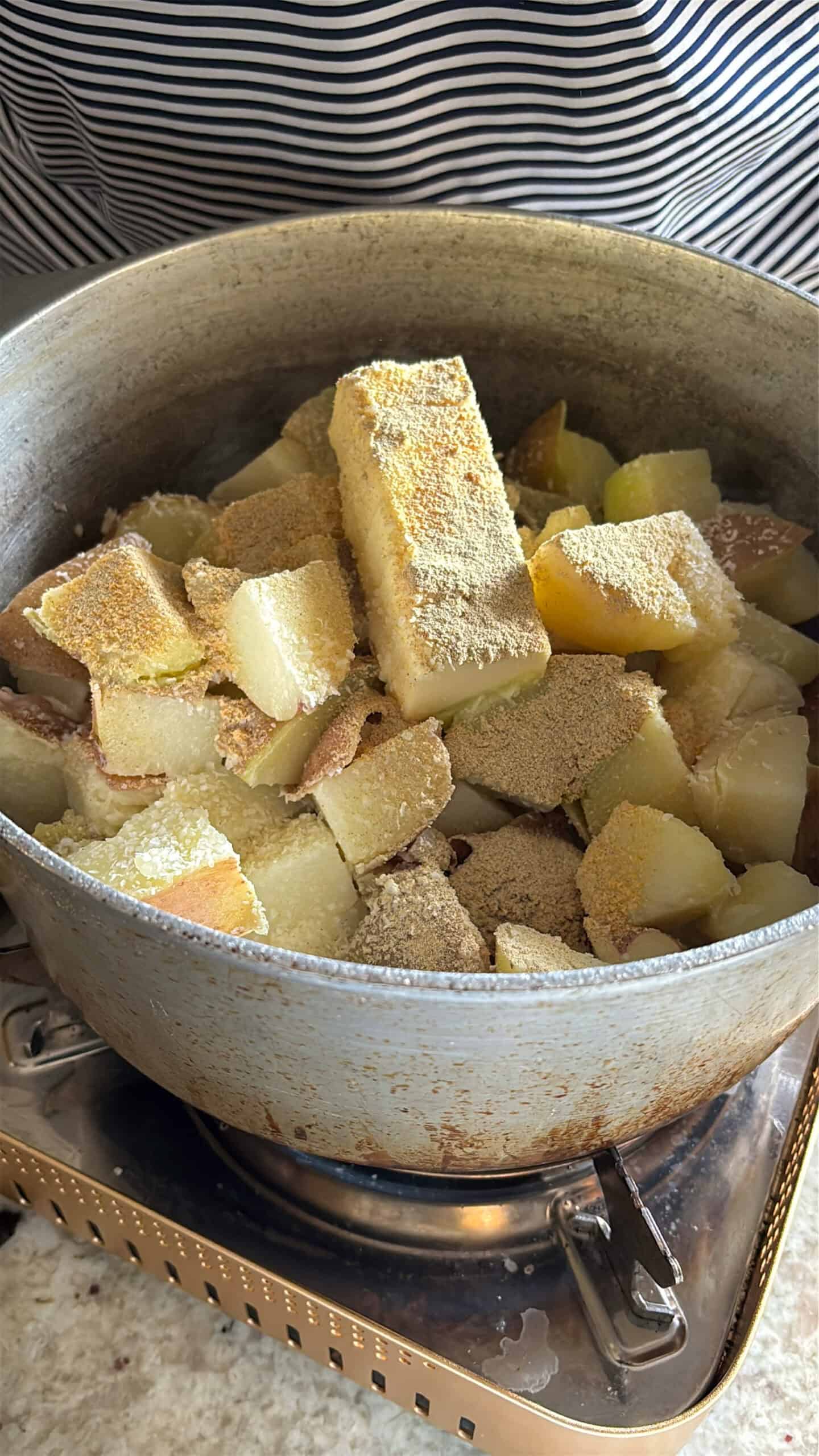 Butter and seasonings added to mashed potatoes pot.