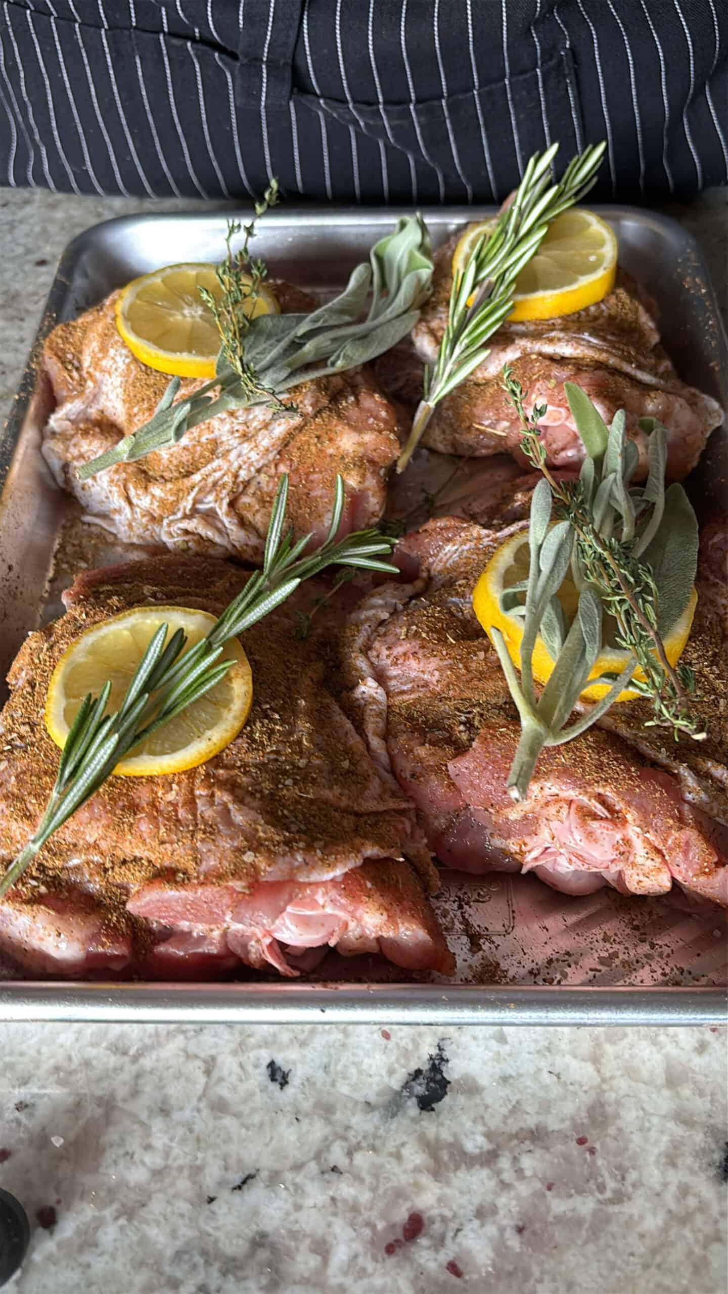 Seasoned turkey thighs with herbs and lemons.