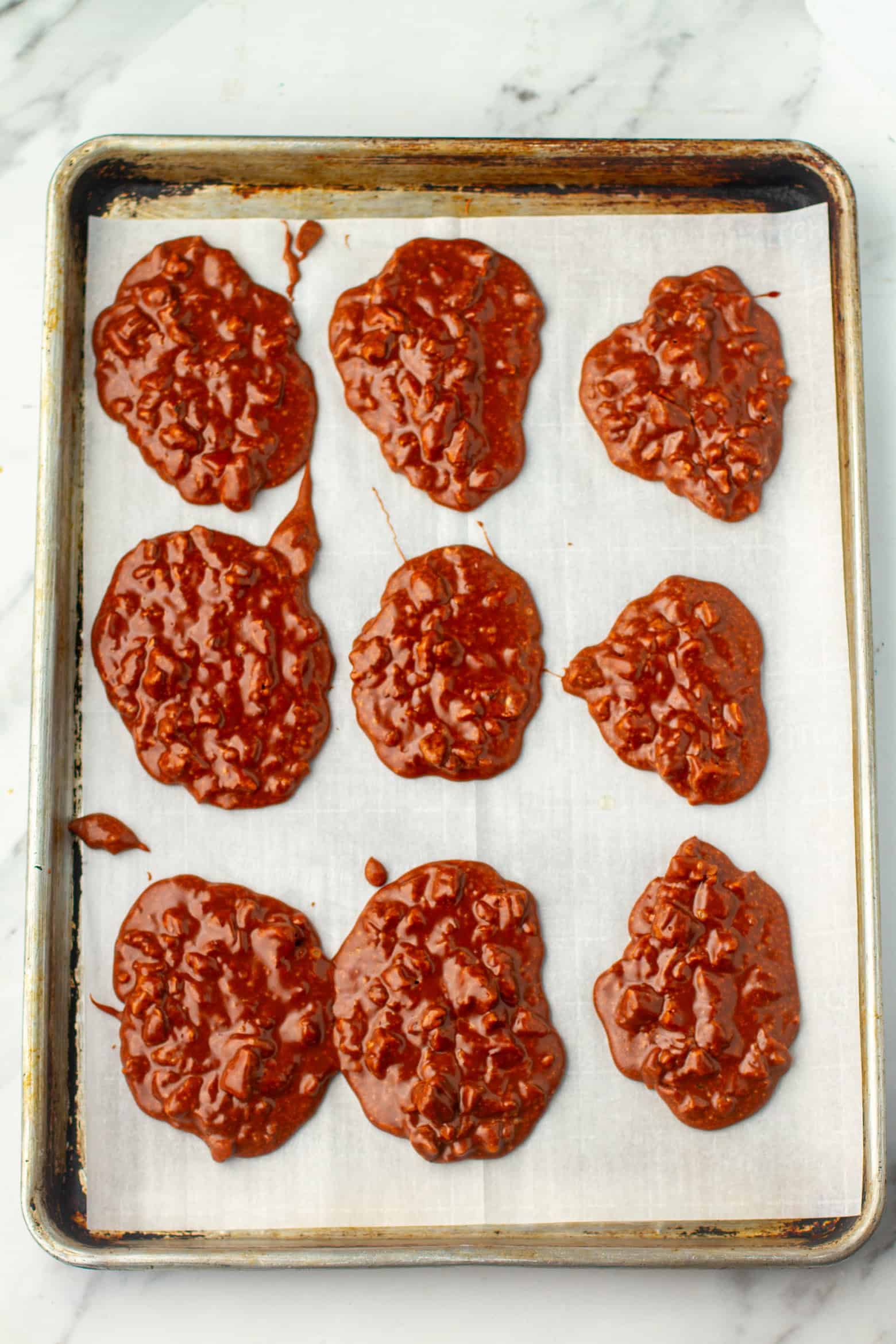 Hot chocolate pralines cooling on a baking sheet.