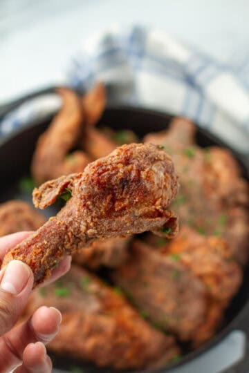 Fried chicken leg being held.
