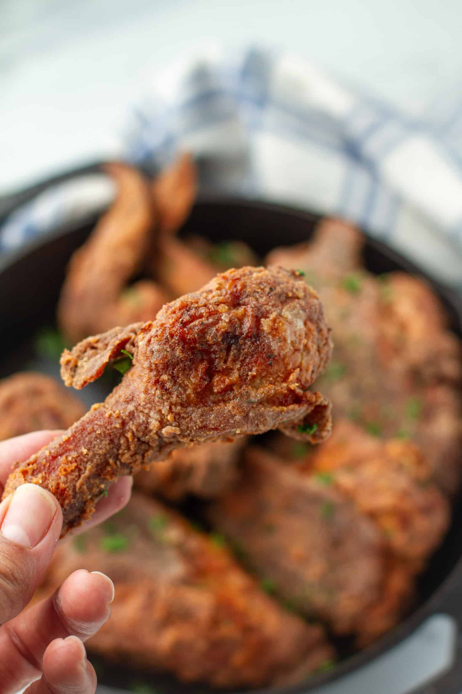 Fried chicken leg being held.