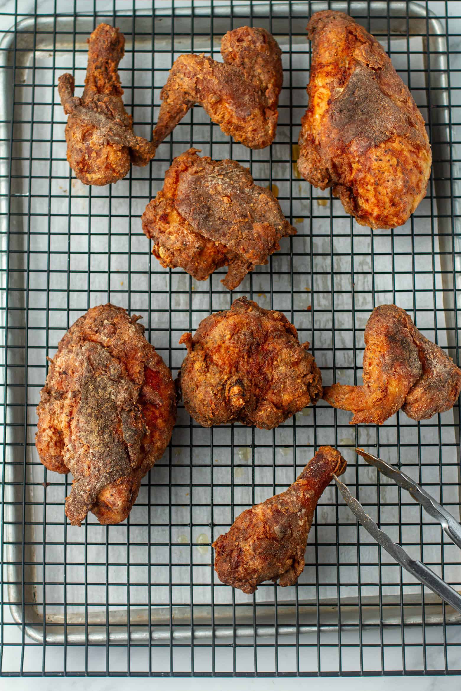 Fried chicken cooling off on a wire rack.
