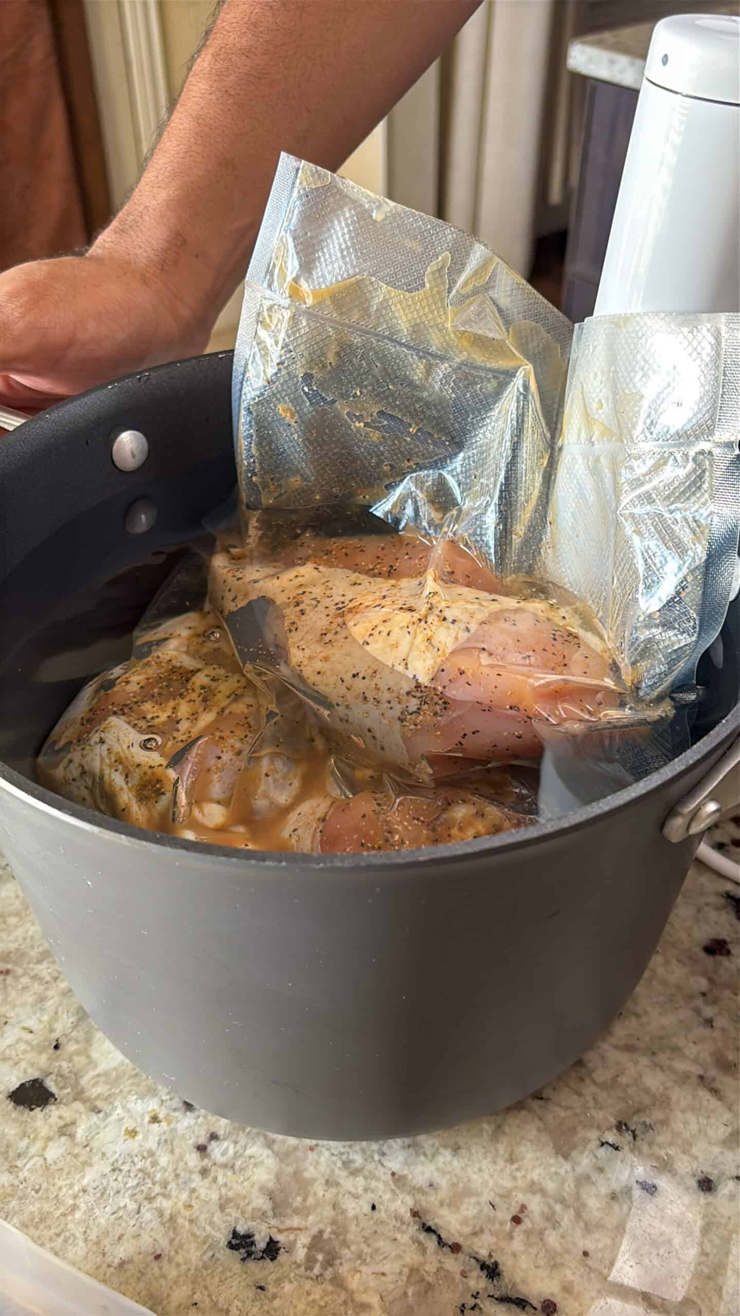 Raw chicken being cooked in a water bath.